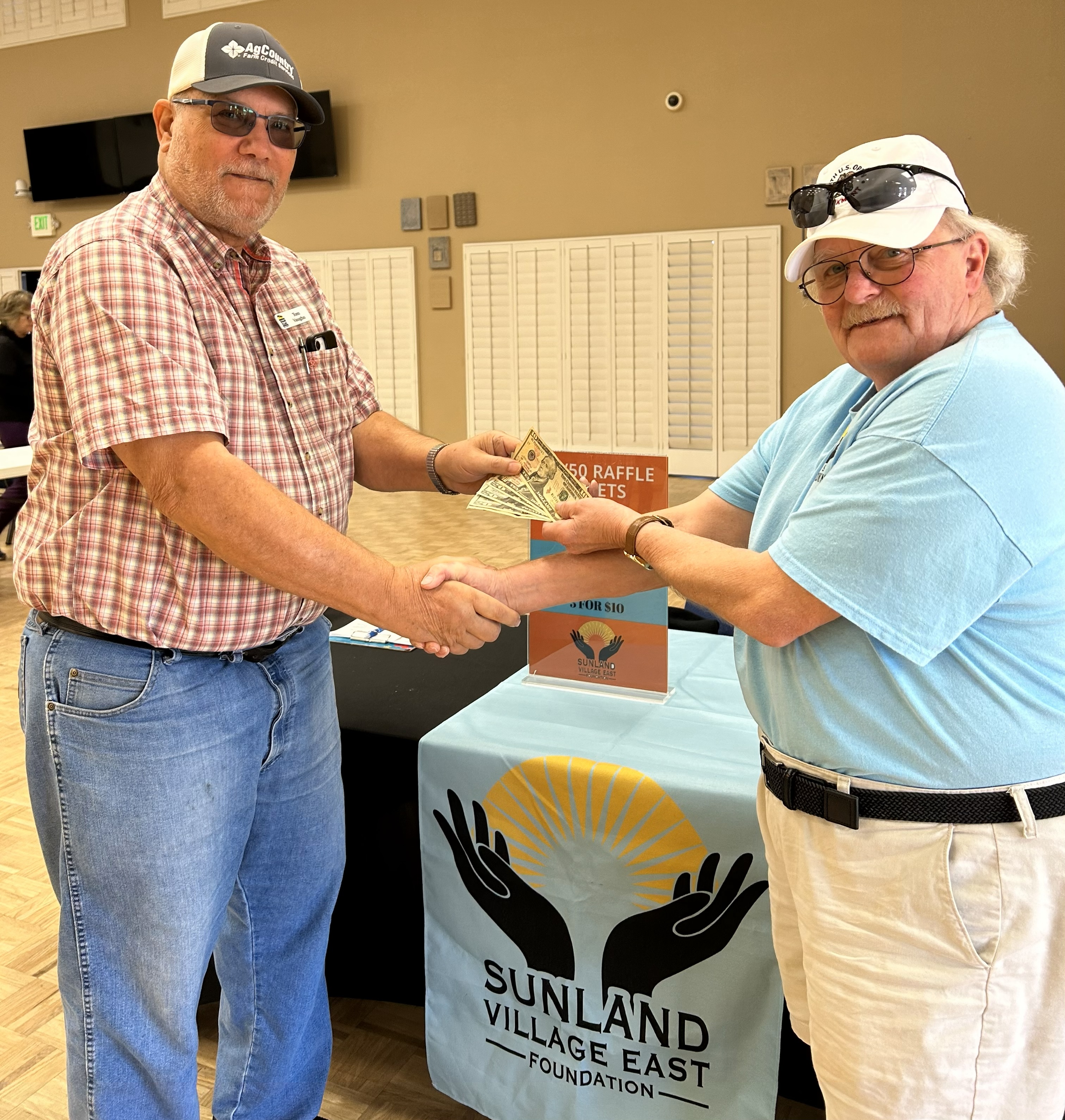 Bill Hopper awarding Tom Vaughn his 50/50 raffle winnings.
